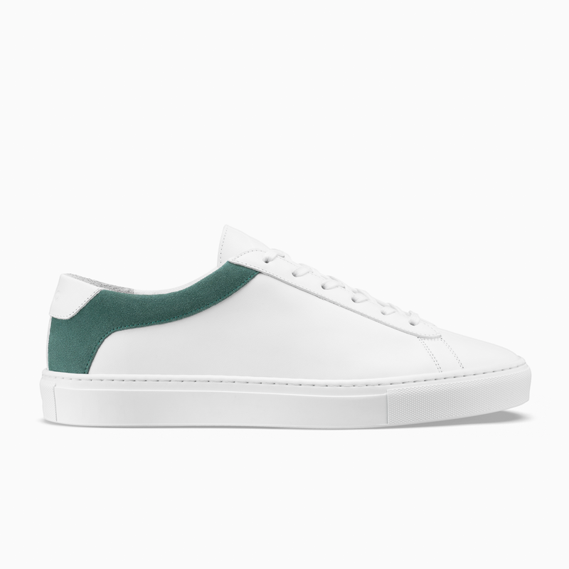 Side view of Capri low-top sneaker showcasing an aloe green suede heel panel with a white background