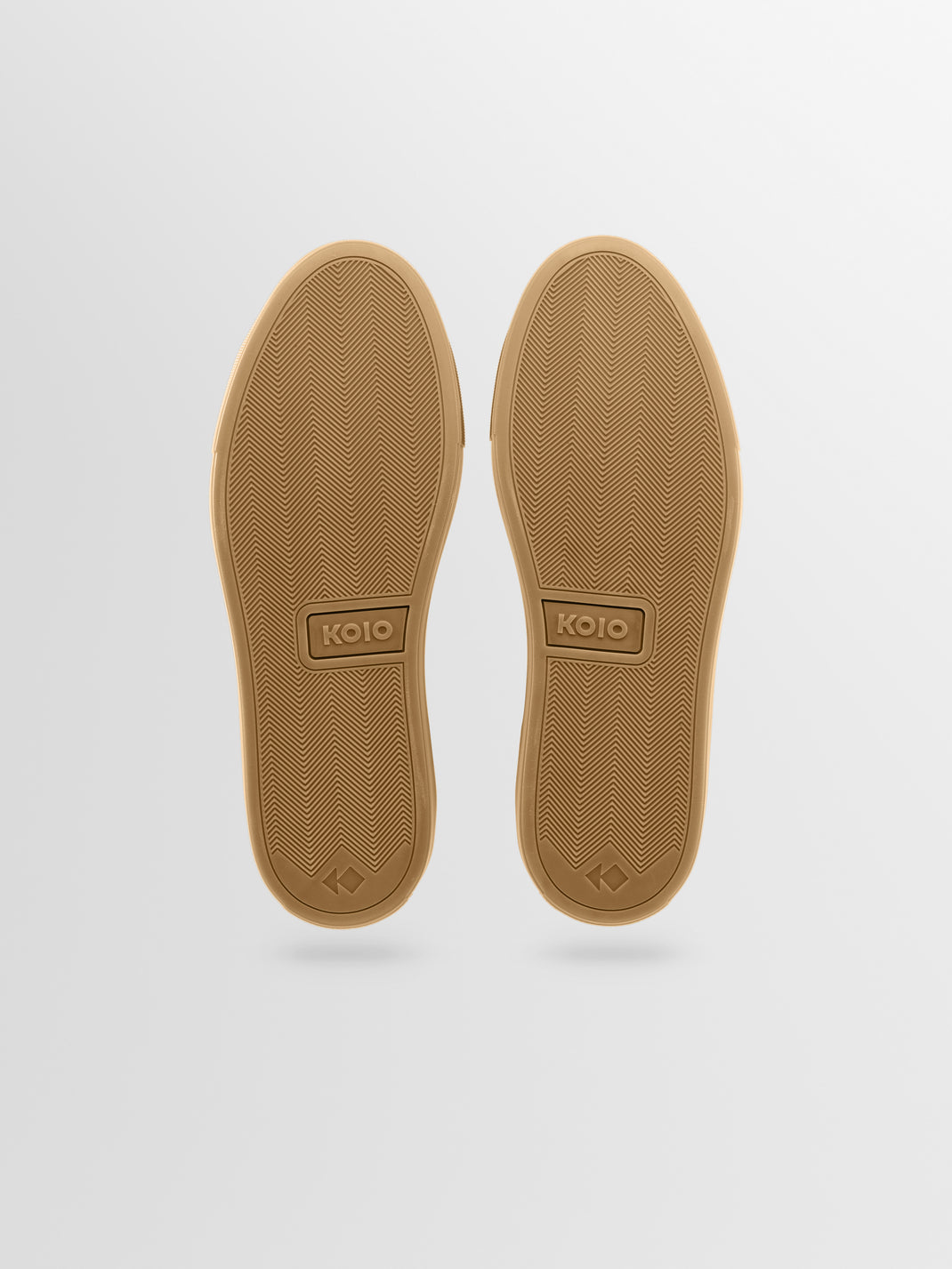 Bottom view of Capri in Antica Forest sneakers showing tan rubber soles with herringbone tread on light gray