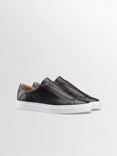 Men's black Italian leather slip on dress sneaker with white rubber sole.