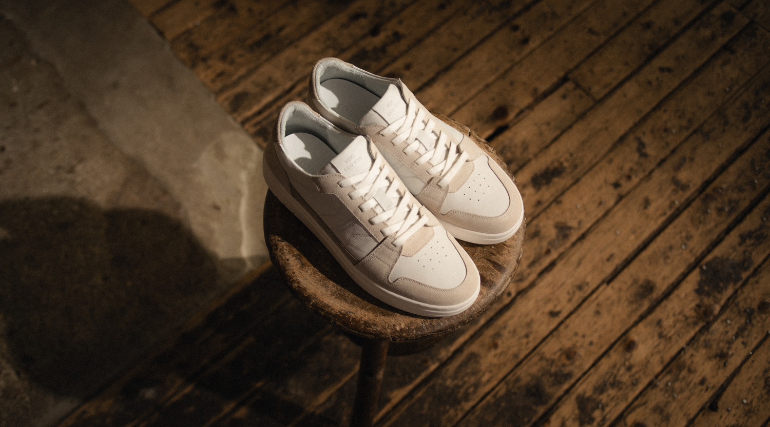 European men's Italian white leather sneakers with beige suede accents, white laces and white rubber soles.