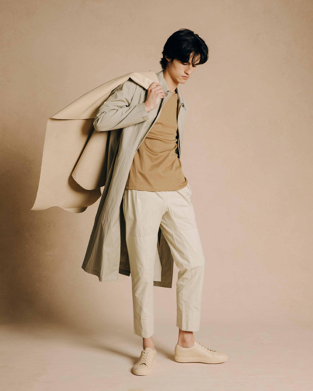 Model wearing limestone Capri low-top sneakers in a neutral studio setting