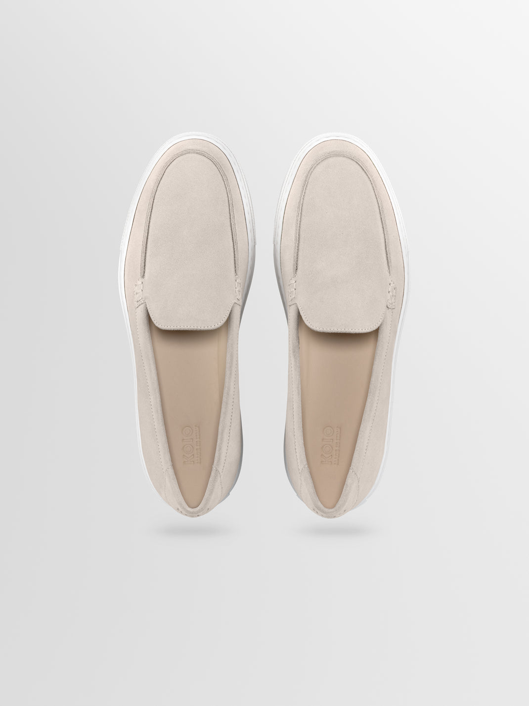 Top view of Lido in Ivory slip-on loafers showcasing suede uppers and white rubber soles on a light gray background
