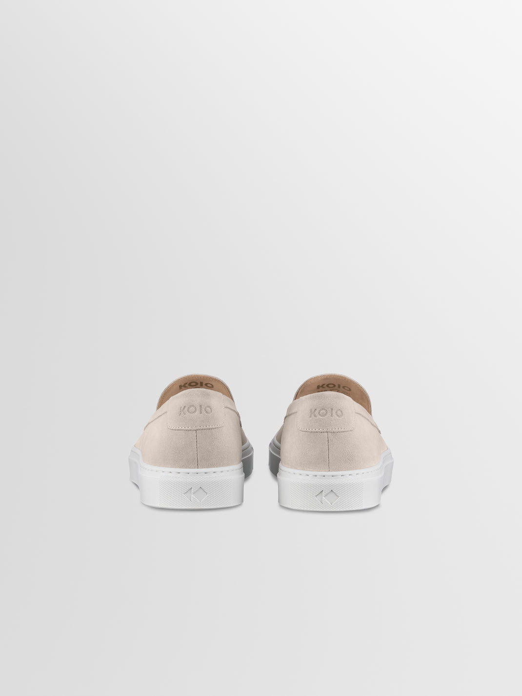 Rear view of Lido in Ivory men’s suede slip-on loafers with white rubber soles and KOIO branding