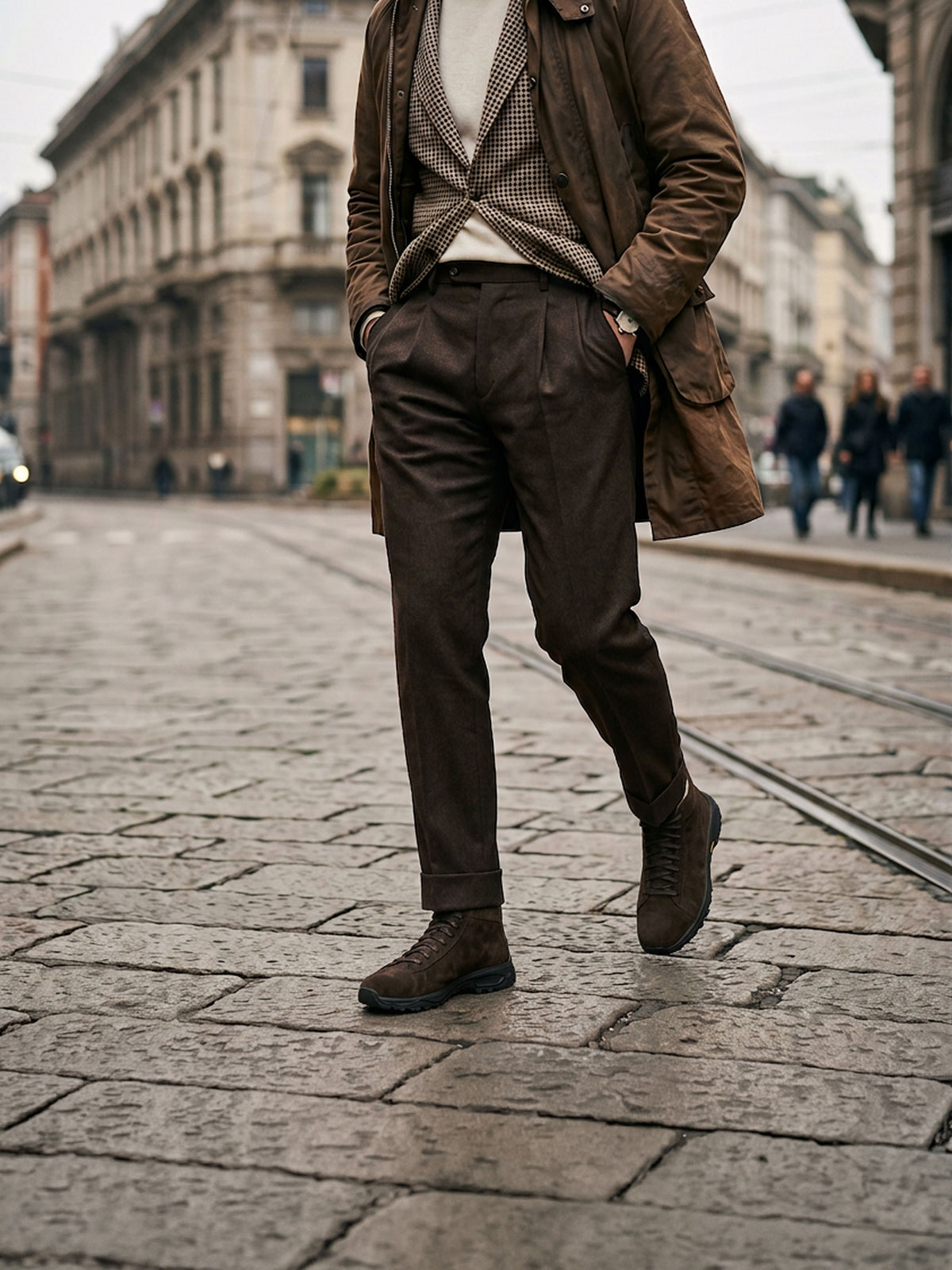 A man wearing a brown leather coat, brown vest, brown trousers, and men