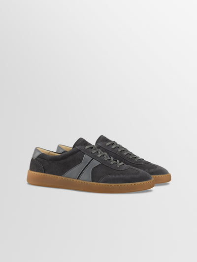 Men's Italian leather dark gray suede lace-up low-top sneaker with a natural gum sole, featuring a tonal gray side stripe and a tan interior lining.