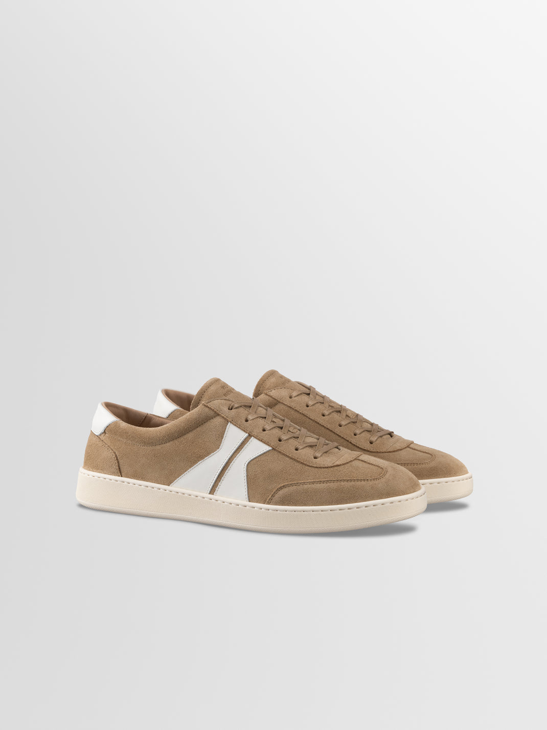 Front three-quarter view of Monza in Wheat low-top sneakers showcasing suede uppers and white side panels on a light gray background